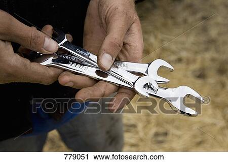 A man holding spanners View Large Photo Image Stock Image - A man holding spanners. Fotosearch