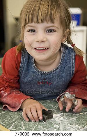 Portrait of a young girl with cookie cutters View Large Photo Image Stock Image - Portrait of a young girl with cookie cutters. Fotosearch