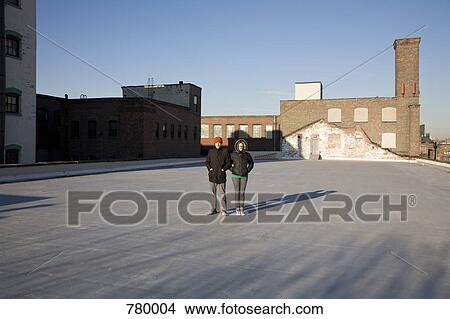 A woman and a man standing on a roof View Large Photo Image Picture - A woman and a man standing on a roof. Fotosearch