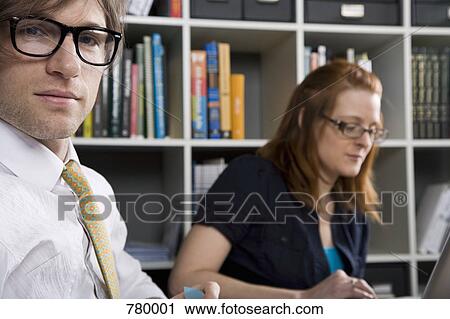Stock Image - Portrait of a businessman with a colleague in the background. Fotosearch