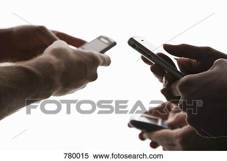 The hands of three people using mobile phones View Large Photo Image Stock Photography - The hands of three people using mobile phones. Fotosearch