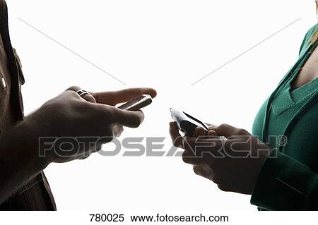 The hands of two people using mobile phones View Large Photo Image Stock Photography - The hands of two people using mobile phones. Fotosearch