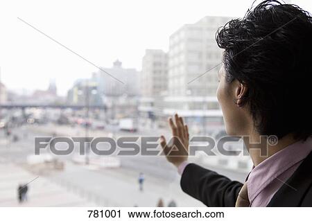 Stock Image - A businessman looking through a window. Fotosearch