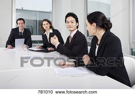 Four business people in a business meeting View Large Photo Image Stock Image - Four business people in a business meeting. Fotosearch