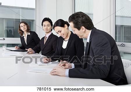 Stock Photography - Four business people in a business meeting. Fotosearch