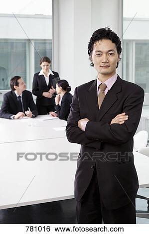 Portrait of a businessman in a board room with out of focus business people in background View Large Photo Image Stock Photograph - Portrait of a businessman in a board room with out of focus business people in background. Fotosearch