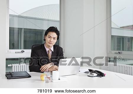 Portrait of a businessman sitting at his office desk View Large Photo Image Stock Photo - Portrait of a businessman sitting at his office desk. Fotosearch