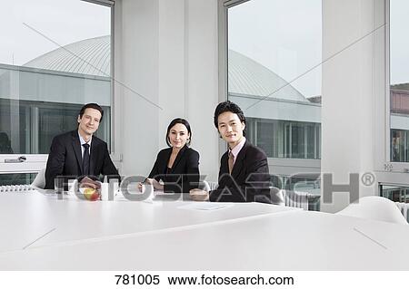 Stock Photography - Portrait of three business people in a meeting. Fotosearch