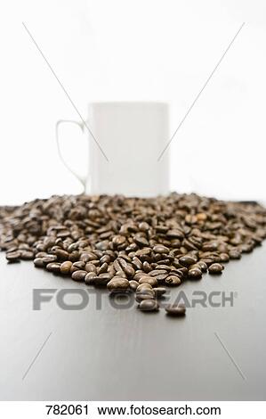 A mug on top of a heap of coffee beans View Large Photo Image Stock Image - A mug on top of a heap of coffee beans. Fotosearch