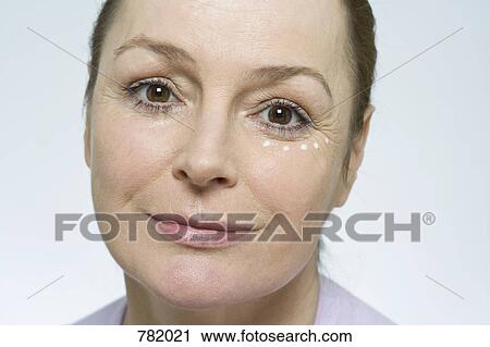 Stock Image - A woman applying face cream. Fotosearch