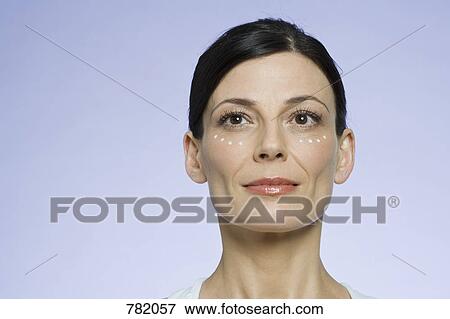 Stock Photo - A woman applying face cream. Fotosearch