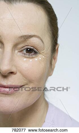 Stock Photo - A woman applying face cream. Fotosearch