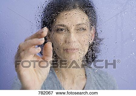 A woman behind wet glass View Large Photo Image Stock Photo - A woman behind wet glass. Fotosearch