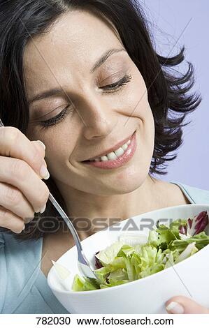 A woman eating a bowl of salad View Large Photo Image Stock Image - A woman eating a bowl of salad. Fotosearch