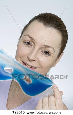 Stock Image - A woman holding an eye mask. Fotosearch