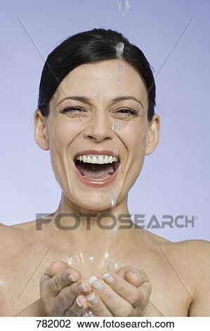 A woman laughing and catching falling water in her hands View Large Photo Image Stock Image - A woman laughing and catching falling water in her hands. Fotosearch