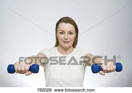 Stock Photo - A woman lifting dumbbells. Fotosearch