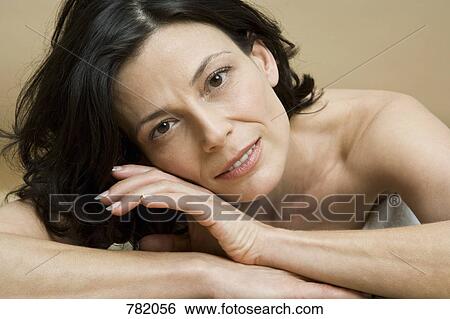 Stock Photograph - A woman lying on her front relaxing. Fotosearch