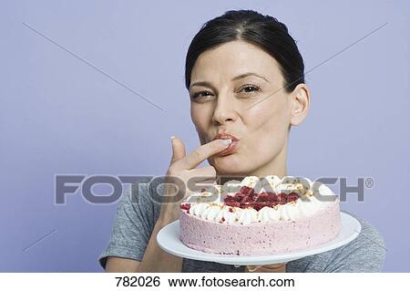 A woman tasting a cake with her finger View Large Photo Image Stock Photograph - A woman tasting a cake with her finger. Fotosearch
