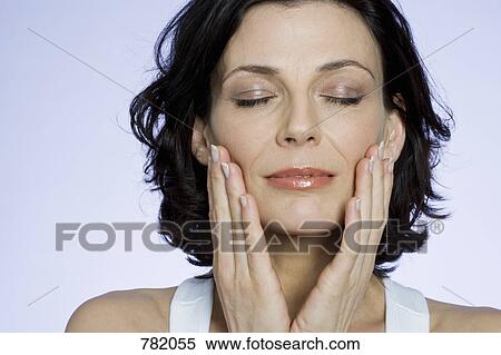 A woman touching her cheeks sensually View Large Photo Image Stock Photography - A woman touching her cheeks sensually. Fotosearch