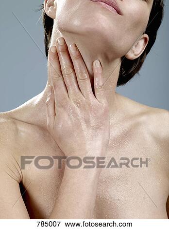 A woman with wet skin touching her neck View Large Photo Image Stock Photo - A woman with wet skin touching her neck. Fotosearch