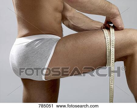 Detail of a man measuring his thigh View Large Photo Image Stock Image - Detail of a man measuring his thigh. Fotosearch