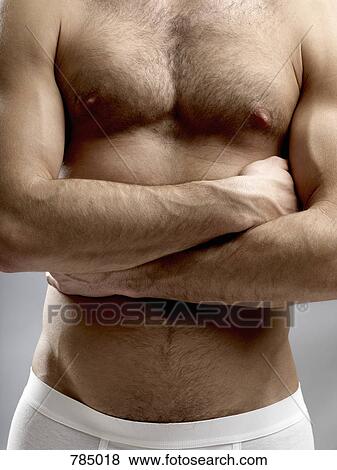 Midsection of a shirtless man with his arms crossed View Large Photo Image Stock Photo - Midsection of a shirtless man with his arms crossed. Fotosearch