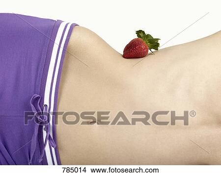 Midsection of a woman balancing a strawberry on her waist View Large Photo Image Picture - Midsection of a woman balancing a strawberry on her waist. Fotosearch