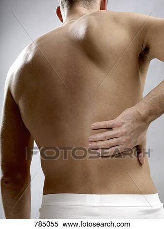Rear view of man touching his back View Large Photo Image Stock Photography - Rear view of man touching his back. Fotosearch