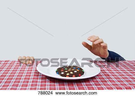 A hand reaching for a cookie View Large Photo Image Picture - A hand reaching for a cookie. Fotosearch