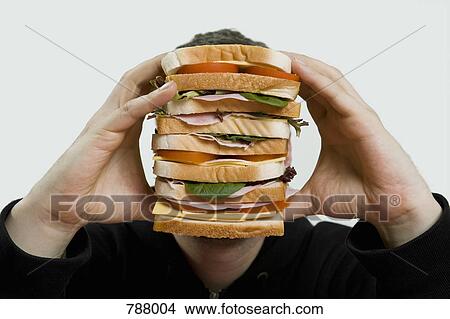 A man holding a large sandwich View Large Photo Image Picture - A man holding a large sandwich. Fotosearch