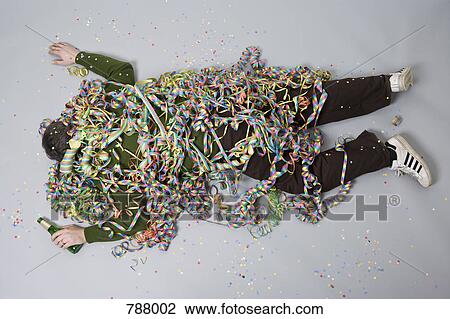 A man passed out and covered in streamers View Large Photo Image Stock Image - A man passed out and covered in streamers. Fotosearch