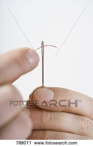 A man threading a needle View Large Photo Image Stock Image - A man threading a needle. Fotosearch