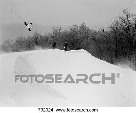 A snowboarder going over a jump, Stratton, Vermont, USA View Large Photo Image Picture - A snowboarder going over a jump, Stratton, Vermont, USA. Fotosearch