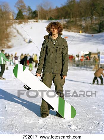 A young man standing with a snowboard at a ski resort, Mountain Creek, New Jersey, USA View Large Photo Image Stock Photo - A young man standing with a snowboard at a ski resort, Mountain Creek, New Jersey, USA. Fotosearch