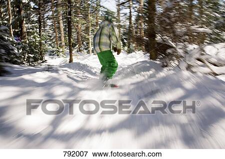 Rear view of a boy snowboarding between trees, Stratton, Vermont, USA View Large Photo Image Stock Photo - Rear view of a boy snowboarding between trees, Stratton, Vermont, USA. Fotosearch
