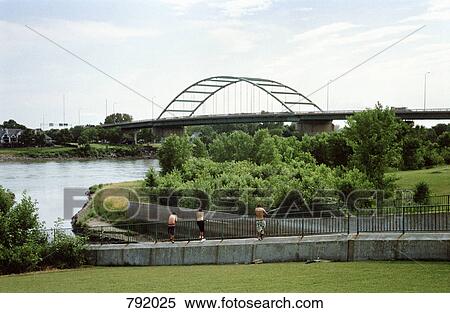 Three men standing by a river, Veteran's Memorial Bridge, Sioux City, Iowa, USA View Large Photo Image Stock Photography - Three men standing by a river, Veteran's Memorial Bridge, Sioux City, Iowa, USA. Fotosearch