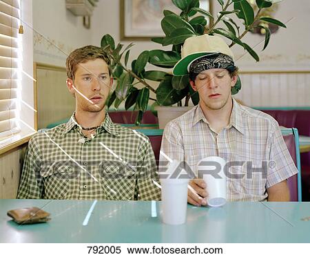 Two young men sitting in a diner View Large Photo Image Stock Photography - Two young men sitting in a diner. Fotosearch