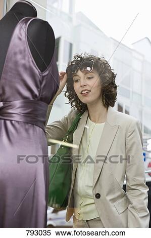 A woman looking at a dress through a store window View Large Photo Image Stock Photography - A woman looking at a dress through a store window. Fotosearch