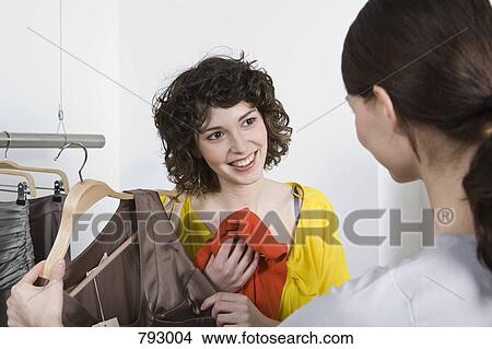 A young woman and sales assistance in a clothing store View Large Photo Image Picture - A young woman and sales assistance in a clothing store. Fotosearch