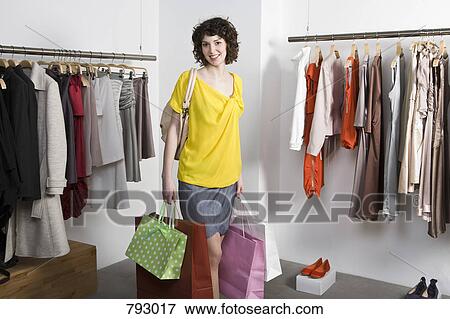 A young woman shopping in a clothing store View Large Photo Image Stock Photo - A young woman shopping in a clothing store. Fotosearch