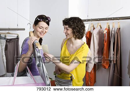 Stock Image - Two friends shopping in a clothing store. Fotosearch