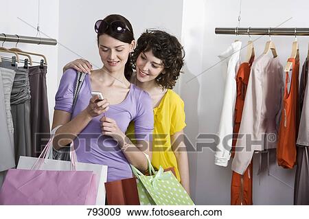 Two friends shopping in a clothing store View Large Photo Image Stock Photo - Two friends shopping in a clothing store. Fotosearch
