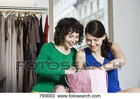 Two young woman in a clothing store View Large Photo Image Stock Image - Two young woman in a clothing store. Fotosearch
