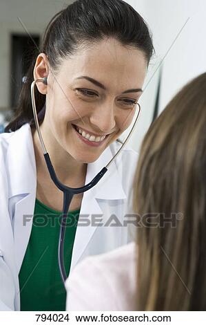 A doctor giving a girl a medical exam View Large Photo Image Picture - A doctor giving a girl a medical exam. Fotosearch