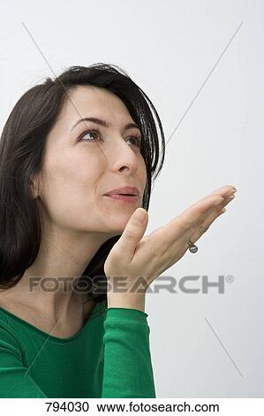 Stock Image - A woman blowing a kiss, portrait. Fotosearch