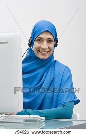 A woman wearing a Hijab and working in a call center View Large Photo Image Stock Photography - A woman wearing a Hijab and working in a call center. Fotosearch