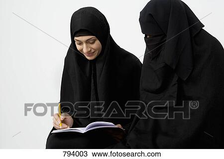 Two women wearing traditional Muslim clothing View Large Photo Image Stock Image - Two women wearing traditional Muslim clothing. Fotosearch