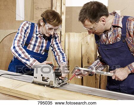 A man assisting a young man sawing wood View Large Photo Image Stock Photography - A man assisting a young man sawing wood. Fotosearch