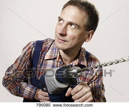 A man holding a large drill View Large Photo Image Stock Image - A man holding a large drill. Fotosearch